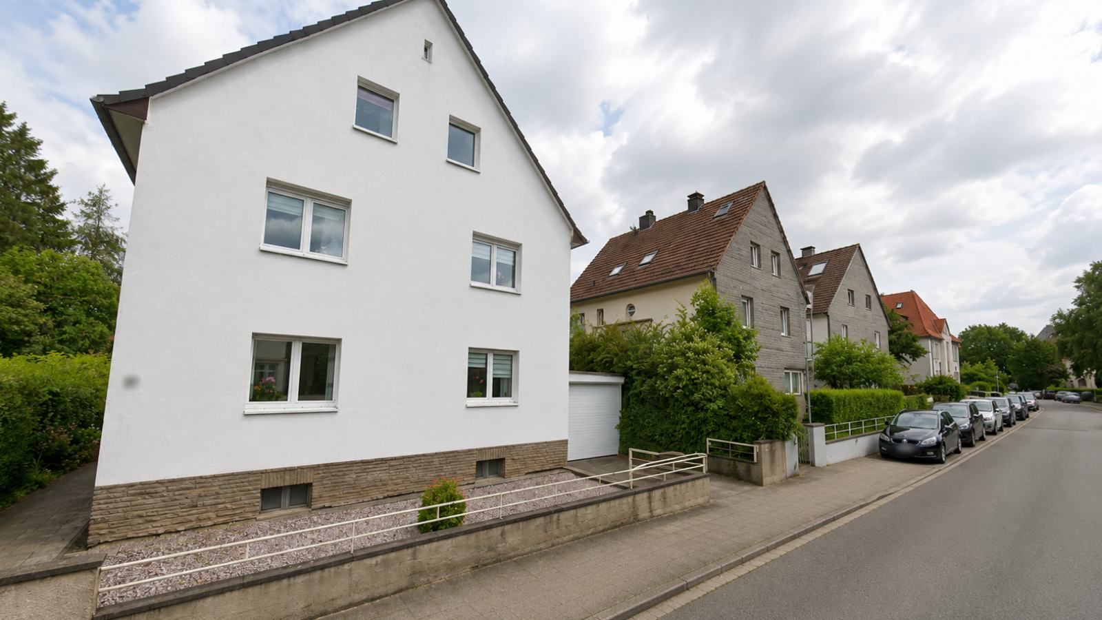 Mehrfamilienhaus mit Bruchsteinsockel an einer Wohnstraße in Iserlohn